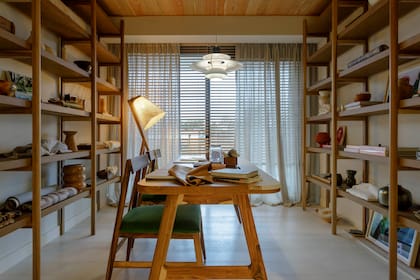 Con cuerpo, las cortinas son de lino pesado. Biblioteca, lámpara de pie 'Citripio Alta', mesa y sillas' Yerta' (Talleres Sustentables).