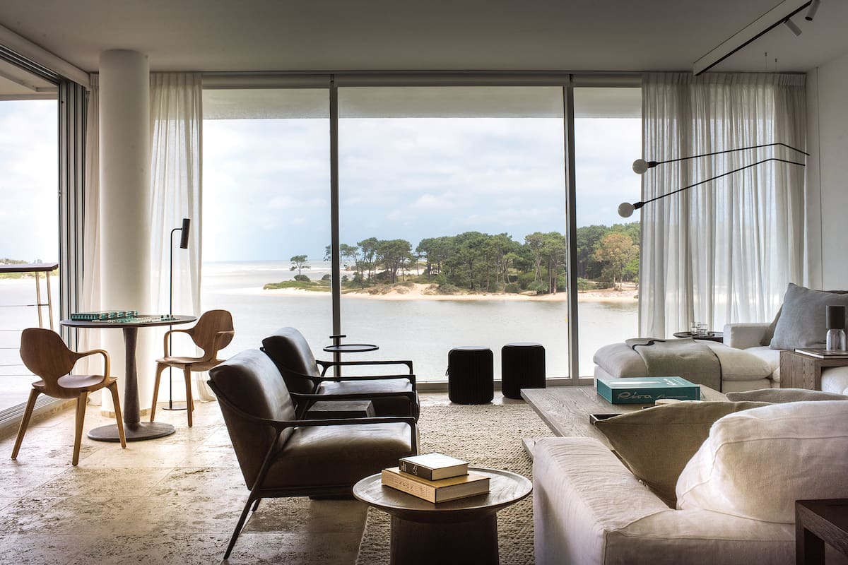 Foto del living de una casa en Punta del Este con sillones individuales de cuero y sillón en L.