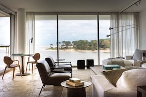 Foto del living de una casa en Punta del Este con sillones individuales de cuero y sillón en L.