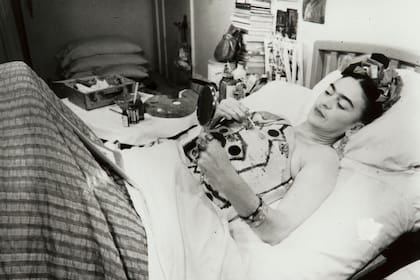 Foto original exhibida en el Malba de Frida pintando su corsé con ayuda de un espejo en el hospital
