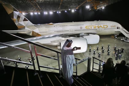 Foto tomada el 18 de diciembre del 2014 de un hombre tomándose un selfie frente a un avión de Etihad Airways en Abu Dabi, Emiratos Árabes Unidos. (AP foto/Kamran Jebreili)