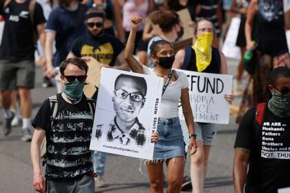 Fotografía de archivo del 27 de junio de 2020, de manifestantes con pancartas mientras marchan por Sable Boulevard durante una manifestación por la muerte de Elijah McClain en Aurora, Colorado. (AP Foto/David Zalubowski, Archivo)