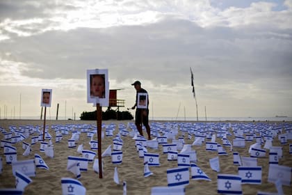 Fotografía difundida por la ONG Río de Paz que muestra banderas de Israel y fotos de niños israelíes víctimas del atentado de Hamás del 7 de octubre en Israel, colocadas como homenaje en la playa de Copacabana en Río de Janeiro, Brasil, el 7 de noviembre de 2023.