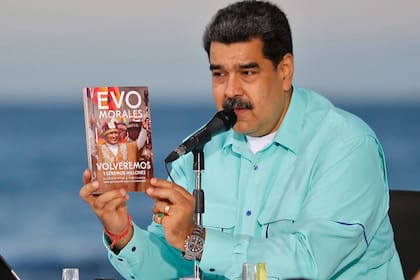 Fotografía distribuida por la presidencia de Venezuela, que muestra a Nicolás Maduro con el libro que le regaló Evo Morales en su visita a al país
