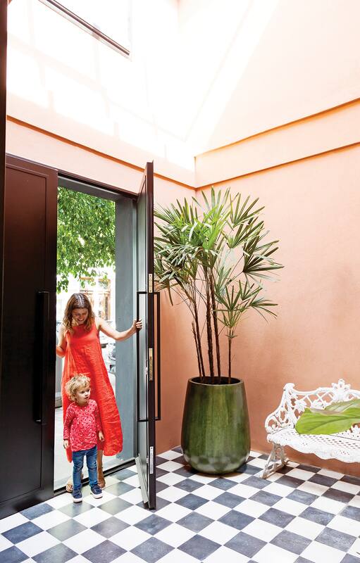 Foto de un patio con revestimiento plástico color terracota y fuente con cerámicos esmaltados.
