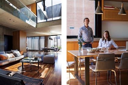 Vanesa y Nacho en el comedor. Lámparas colgantes diseñadas a medida en cerámica y madera (Ambos Lighting). Un toilette casi imperceptible detrás del acceso principal. Todas las puertas son pivotantes para que los planos de madera parezcan siempre revestimiento.