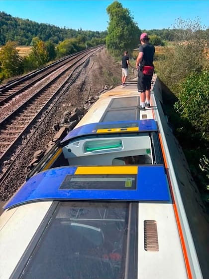 Fotos en redes sociales mostraban al menos dos vagones de lado y a trabajadores de emergencias y otras personas de pie sobre el tren volcado