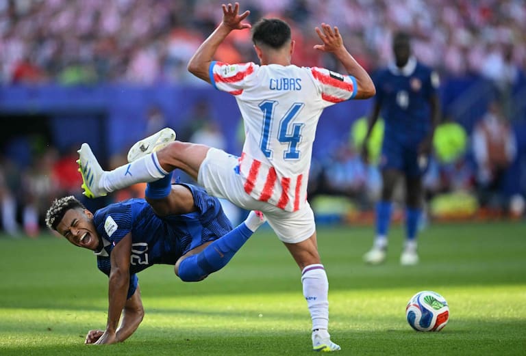 France's forward #20 Desire falls past Paraguay's midfielder #14 Andres Cubas during the 2026 World Cup round of 16 football match between Paraguay and France at the Philadelphia Stadium in Philadelphia on July 4, 2026. (Photo by MAURO PIMENTEL / AFP)