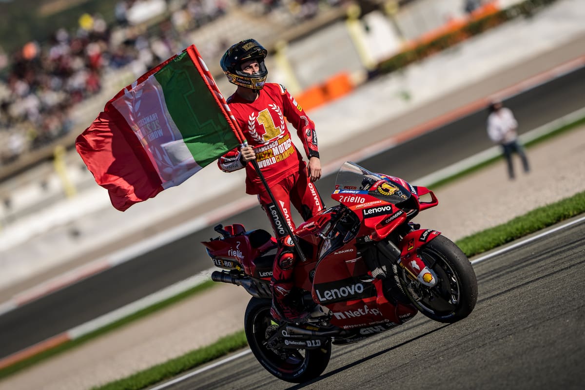 Francesco Bagnaia luce el N°1 en su pecho y la bandera de Italia, sobre la Ducati, durante la vuelta de honor en Cheste; el italiano ensayó una remontada espectacular en la segunda parte de la temporada y se consagró campeón de MotoGP