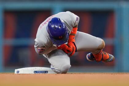 Francisco Álvarez, de los Mets de Nueva York, reacciona a una lesión en la segunda base durante la segunda entrada de un juego de béisbol contra los Dodgers de Los Ángeles en Los Ángeles, el viernes 19 de abril de 2024. (AP Foto/Ashley Landis)