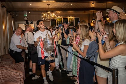 Francisco Cerúndolo, con el trofeo del ATP de Queen's, recorriendo los pasillos del tradicional club londinense, felicitado por el público británico