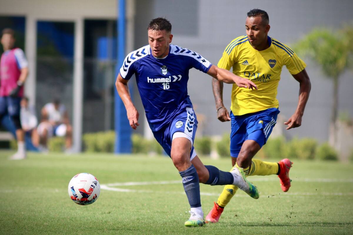 Francisco Gerometta, de Gimnasia, se lleva la pelota ante la marca de Sebastián Villa, quien fue titular en Boca durante el amistoso disputado este viernes en el predio de entrenamiento del club xeneize, en Ezeiza