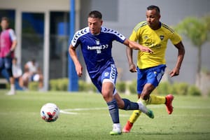 Francisco Gerometta, de Gimnasia, se lleva la pelota ante la marca de Sebastián Villa, quien fue titular en Boca durante el amistoso disputado este viernes en el predio de entrenamiento del club xeneize, en Ezeiza