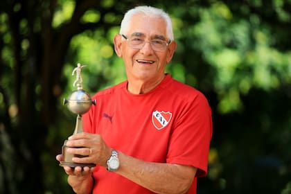 Francisco "Pancho" Sá en el patio trasero de su casa, posando con una réplica de la Copa Libertadores.