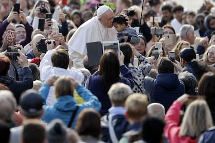 Francisco saludó a un chico durante su recorrido en la Plaza San Pedro antes de la audiencia general