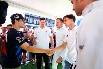 Franco Colapinto en el paddock, con miembros del equipo húngaro de esgrima