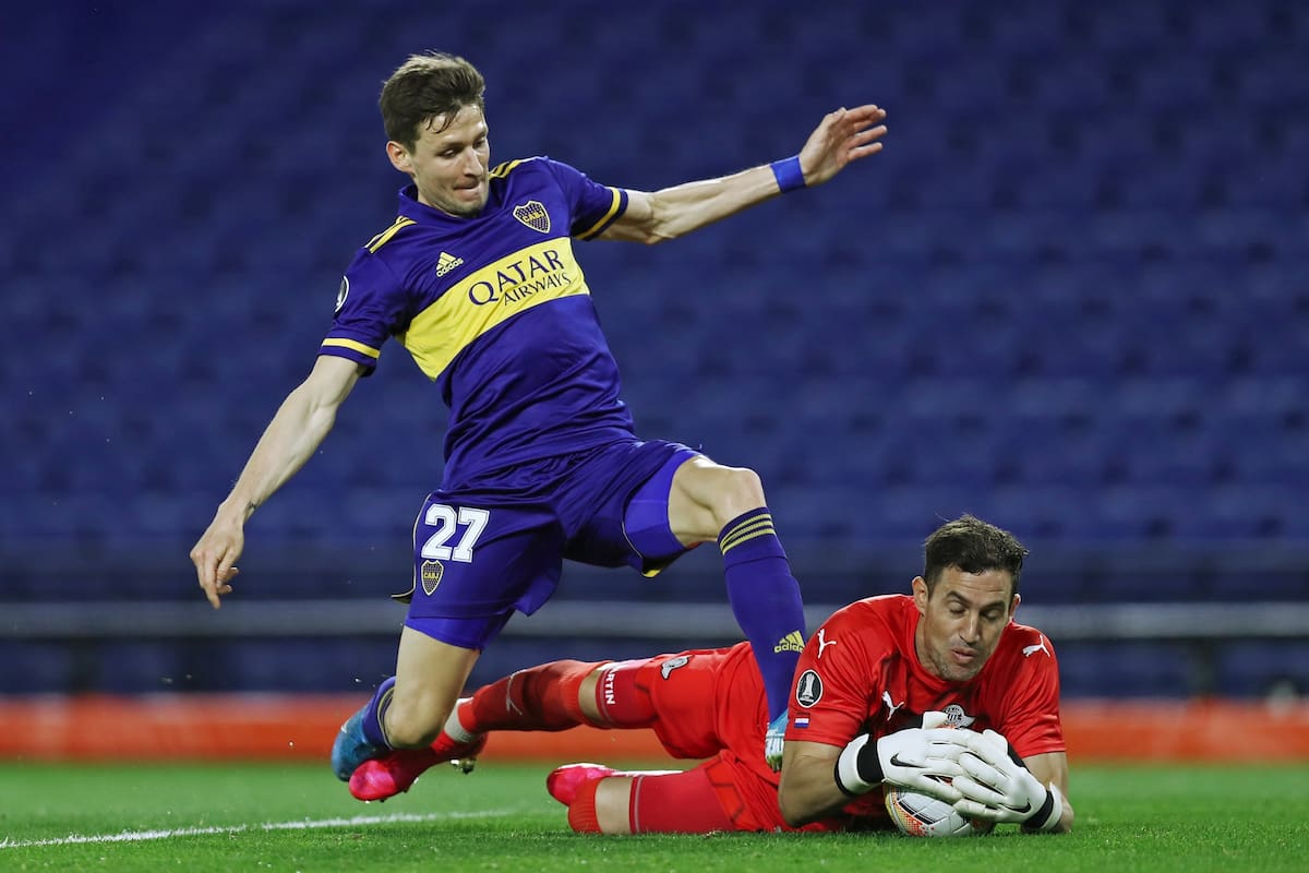 Franco Soldano de Boca Juniors lucha por la pelota con el arquero de Libertad Martin Silva.