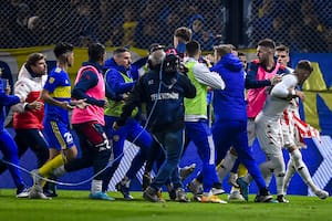 Franco Troyanski mostró su camiseta a una de las populares tras convertir el penal decisivo y los futbolistas de Boca se abalanzan sobre él, mientras lo defienden sus compañeros de Unión.