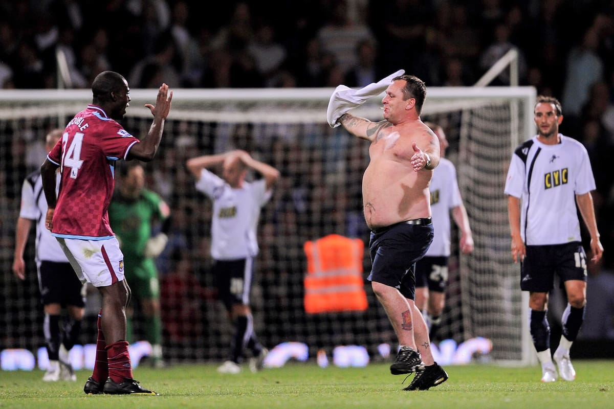 Frank Nouble, jugador de West Ham, intenta impedir que los hinchas ingresen al campo de juego durante el recordado duelo ante Millwall, el 25 de agosto de 2009, en Upton Park