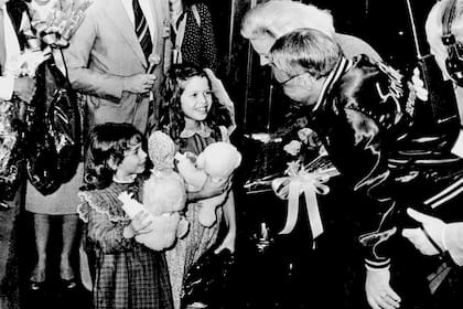 Frank y su esposa Barbara arriban a Ezeiza el 2 de agosto de 1981; Julieta Ortega, de 9 años, sonríe luego de entregarles un ramo