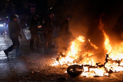 Una moto incendiada después del partido de fútbol de los cuartos de final de la Copa del Mundo, cerca de la avenida Champs Elysee, en París, el sábado 10 de diciembre de 2022