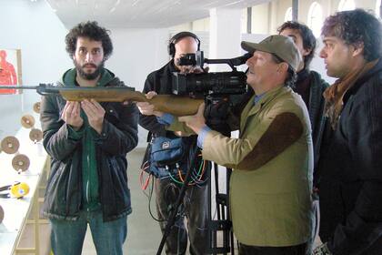 Frenkel mira desde atrás la toma con Mario, que sostiene el rifle durante el rodaje de Amateur (2011)