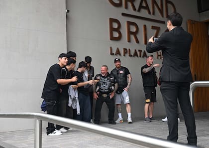 Frente al hotel Grand Brizo, en pleno centro de La Plata, varios integrantes de los Hell’s Angels posan sonrientes con vecinos curiosos