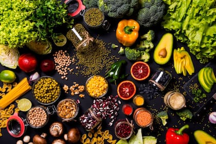 Fresh vegetables and fruits on black background. Detox diet. Different colorful fresh vegan food. Flat lay.