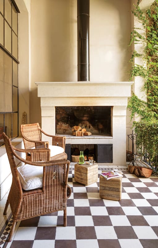 El patio con piso damero y chimenea –que es parrilla y hogar en invierno– es el nexo entre la cocina y la fronda.