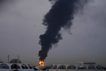 Fuego y humo se elevan después de que un dron golpeara un depósito de combustible y obligara a suspender de forma temporal los vuelos cerca del aeropuerto internacional de Dubái
