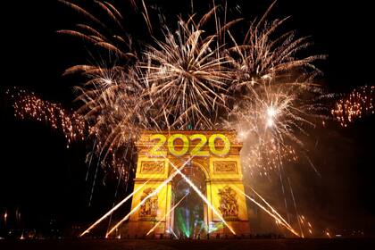 Fuegos artificiales y proyecciones iluminan el Arco de Triunfo en París, Francia