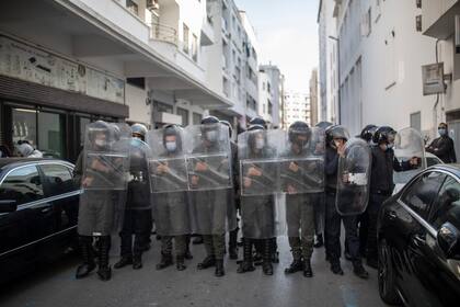 Fuerzas de seguridad montan guardia tras dispersar una protesta contra el requerimiento gubernamental de un pase de COVID-19 para acceder a lugares públicos y viajar en Rabat, Marruecos, el 27 de octubre del 2021.  (AP Foto/Mosa'ab Elshamy)