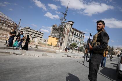 Fuerzas de seguridad sirias montan guardia mientras residentes abandonan los barrios de Sheikh Maqsoud y Achrafieh en Alepo, Siria, el 7 de octubre del 2025. (AP foto/Omar Albam)