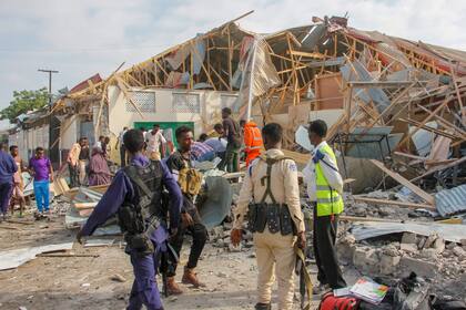 Fuerzas de seguridad y rescatistas buscan cuerpos en el lugar de una explosión en Mogadiscio, Somalia, el jueves 25 de noviembre de 2021. (AP Photo/Farah Abdi Warsameh)