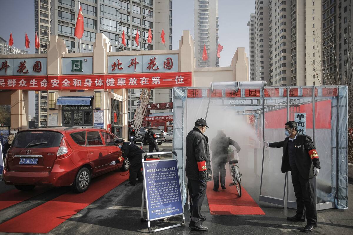 Funcionarios de salud rocían con desinfectante a un ciclista en Tianjin