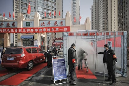 Funcionarios de salud rocían con desinfectante a un ciclista en Tianjin