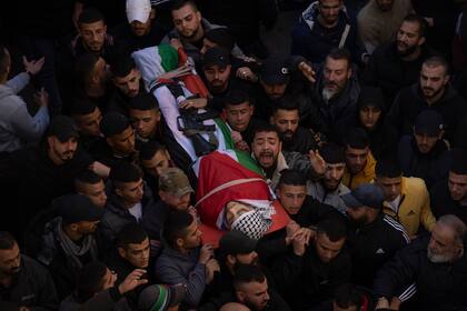 Funeral de Ahmed Abu Junaid, de 21 años, en el campo de refugiados de Balata, Cisjordania, el jueves 12 de enero de 2023. Junaid, quien es palestino, murió luego de una redada de militares israelíes. (Foto AP/Nasser Nasser)