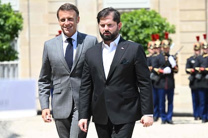 Gabriel Boric camina junto a Emmanuel Macron en el Palacio del Elíseo, en París. (Bertrand GUAY / AFP)