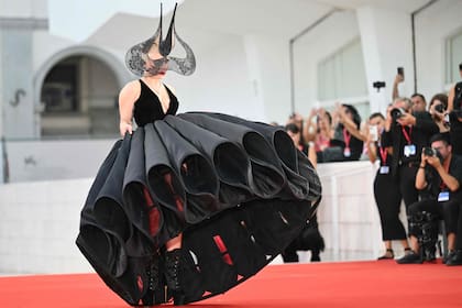 Gaga lució un estructurado diseño de Dior Haute Couture, que acompañó con un fascinator con visera de encaje y unas botas de terciopelo con plataforma