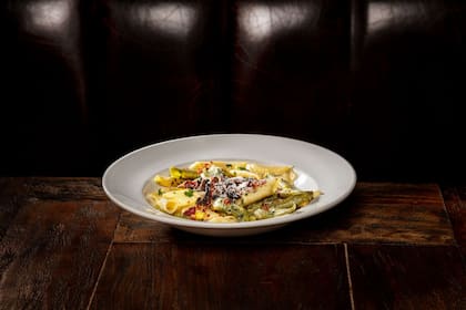 Garganelli (pasta a base de huevo que se forma al enrollar un fideo plano y cuadrado en forma cilíndrica) con crema de puerro, maíz y portobello