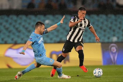 Gary Kagelmacher intenta detener al argentino Tomás Cuello; Atlético Mineiro jugará la final de la Copa Sudamericana con Boca en Barranquilla