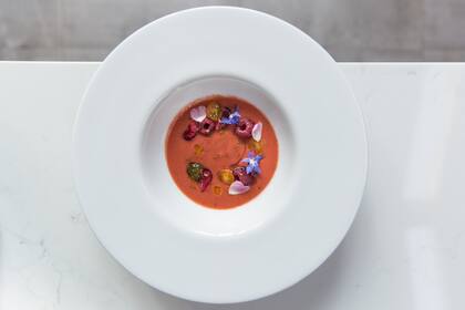 Gazpacho de tomates y cerezas negras, frambuesas y flores comestibles.
