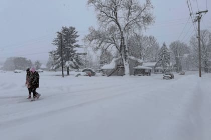 Gente camina entre la nieve en Lowville, Nueva York. (AP Foto/Cara Anna)