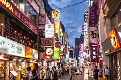 Gente camina por una calle peatonal del distrito comercial de Myeong-dong, en Seúl