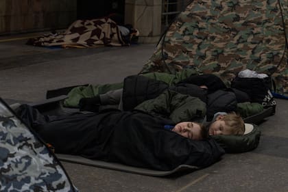 Gente cobijada en una estación de trenes subterráneos utilizada como refugio antibombas durante un ataque de drones rusos en Kiev, Ucrania