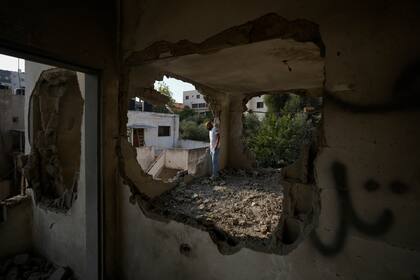 Gente mirando a la vivienda demolida del pistolero palestino Raed Hazem, que protagonizó un ataque mortal en Tel Aviv en abril, después de que fuera destruida por fuerzas israelíes en la ciudad cisjordana de Yenín, el martes 6 de septiembre de 2022. (AP Foto/Majdi Mohammed)
