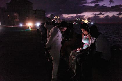 Gente pasa la noche en la oscuridad en el Malecón durante un apagón en La Habana