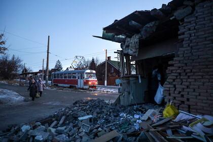 Gente pasando junto a una casa dañada por lo que autoridades rusas en Donetsk dijeron que había sido un ataque ucraniano en Donetsk, en la región de Donetsk controlada por Rusia, en el este de Ucrania, el martes 10 de enero de 2023. (AP Foto)