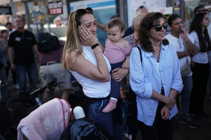 Gente reacciona mientras se reúne para ver una emisión en vivo de la liberación de rehenes israelíes desde Gaza, en un lugar conocido como la Plaza de los Rehenes, en Tel Aviv, Israel, el 13 de octubre de 2025. La liberación se produjo dentro de un acuerdo de cese el fuego entre Israel y Hamás. (AP Foto/Oded Balilty)
