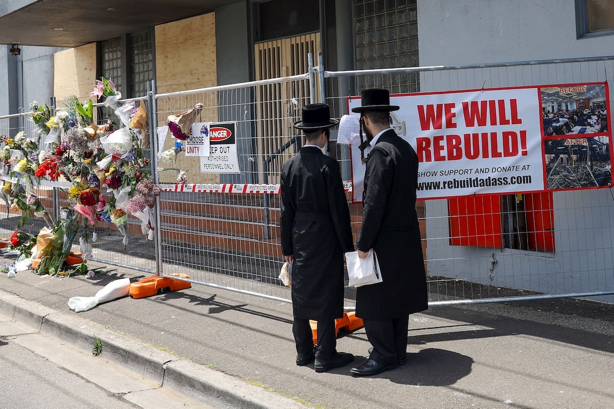 Gente reunida ante la sinagoga Adass Israel, dañada por un incendio provocado en Melbourne, Australia, en diciembre de 2024.